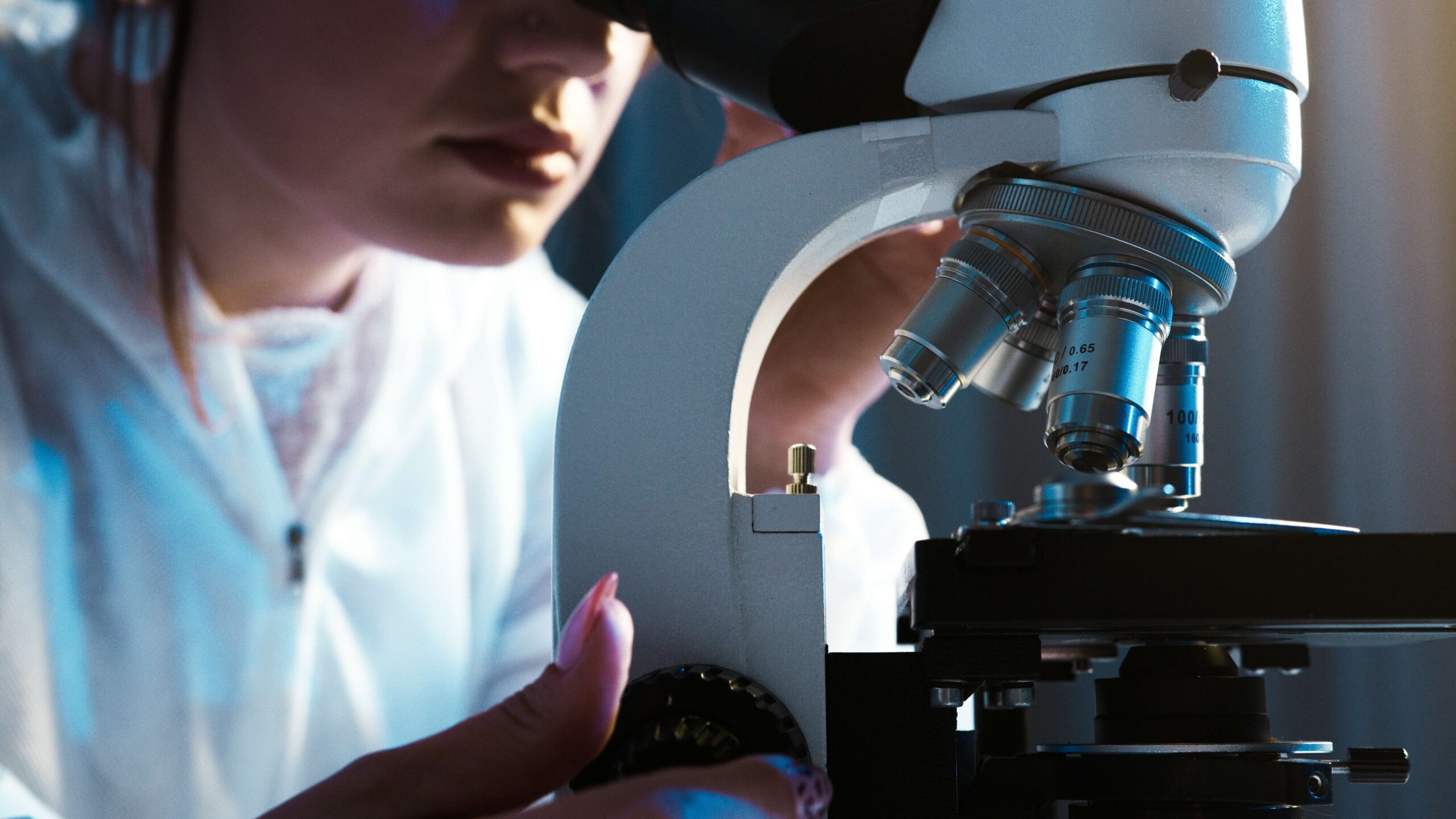 Výzkumný pracovník v laboratoři se dívá do mikroskopu